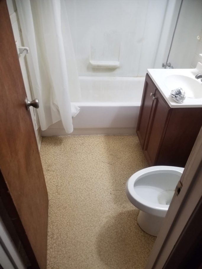 Small bathroom featuring a bathtub, toilet, sink, and light-colored flooring.